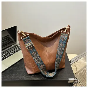 Detailed texture of brown lychee grain faux leather tote with floral jacquard strap