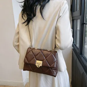 Classic dark brown quilted leather crossbody bag with gold chain strap on model