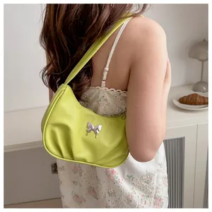 Détail du sac à épaule froncé vert citron avec papillon argenté sur un mannequin