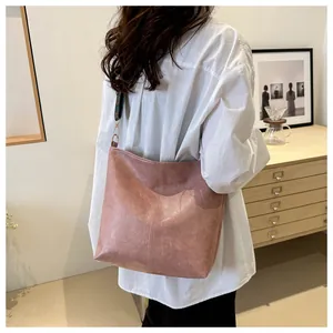 Detail view of pink leather tote bag featuring a colorful vintage ethnic patterned strap