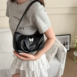 Sac à bandoulière plissé noir minimaliste avec papillon argenté et texture cuir brillant