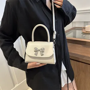 Chic cream bow shoulder bag for women with silver metal buckle and top handle