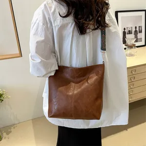 Brown vintage faux leather tote bag with a bohemian floral wide shoulder strap