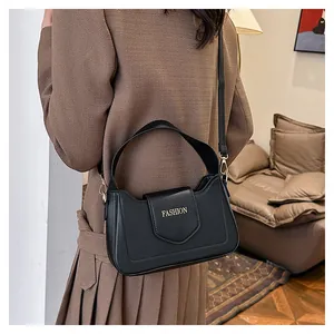 Détail d'un sac bandoulière en cuir PU noir avec inscription FASHION dorée