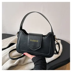 Détail du sac à bandoulière en similicuir noir avec texte FASHION doré et anse