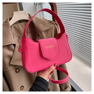 Détail du sac à bandoulière en similicuir rose avec logo 'FASHION' doré et poignée