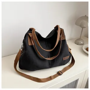 Detail of black canvas tote bag showing the Fashion leather tag and brown strap