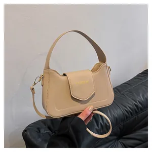 Détail d'un sac à main crème en cuir PU avec logo doré et bandoulière amovible élégante