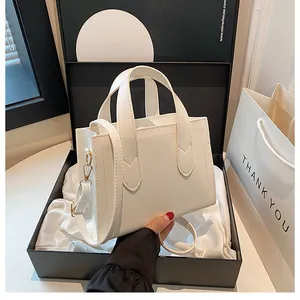 Close-up of premium cream faux leather tote bag with top handles inside a gift box