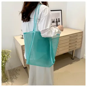 Detalle del bolso tote de malla verde menta con tejido de nailon y correas anchas