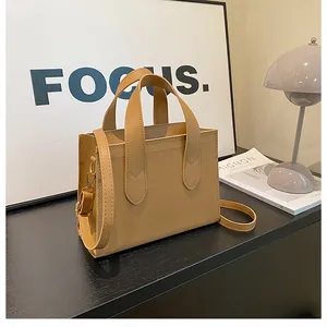 Detailed view of camel faux leather tote bag with gold hardware and shoulder strap