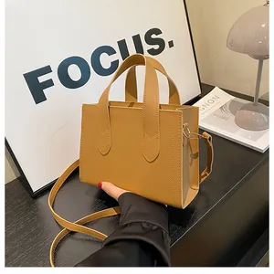 Detail of light brown matte tote bag showing high-quality stitching and dual top handles