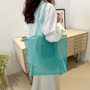 Bolso tote de malla azul turquesa con correas de hombro en un ambiente de estilo minimalista