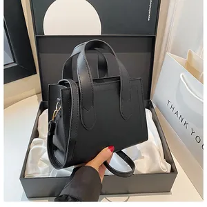 Unboxing detail of a premium black leather handbag with luxury gift box and shopping bag