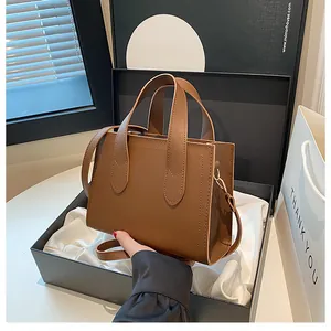 Detailed view of brown leather handbag placed in an elegant gift box with satin lining