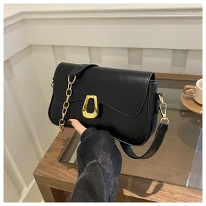 Close-up of black shoulder bag with wavy flap design and gold hardware detail