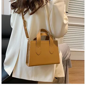Khaki PU leather tote bag shown with a white blazer for a professional commuter style