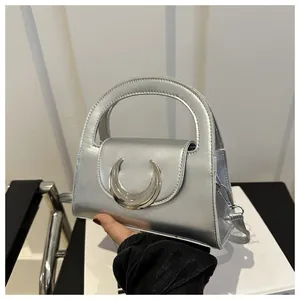 Detail of silver metallic semi-circle handbag with crescent hardware and detachable strap