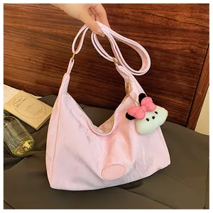 Pink crescent shoulder bag with pleated texture and cute puppy charm detail