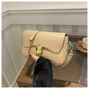 Detail of cream PU leather shoulder bag with wavy flap and golden horseshoe buckle