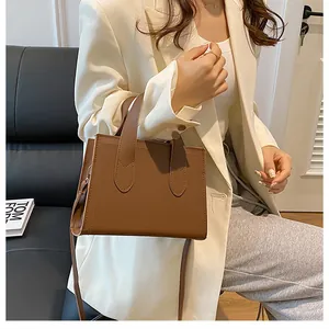 Brown rectangular shoulder bag in matte leather shown on model for daily commuting style