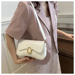 Detail of white leather shoulder bag featuring an elegant gold U-shaped metal buckle