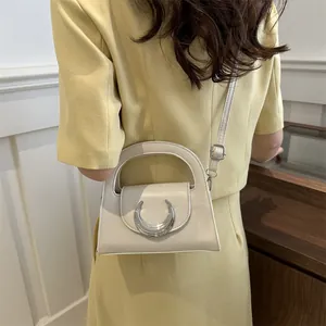 Elegant cream semi-circle handbag with silver moon buckle decoration and top handle strap