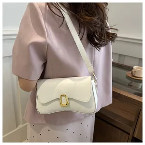 Detail of a chic cream-colored PU leather shoulder bag with a gold geometric buckle