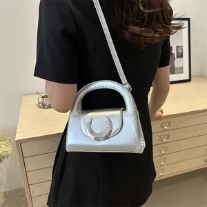 Metallic silver semicircular handbag with large moon-shaped handle and crossbody strap