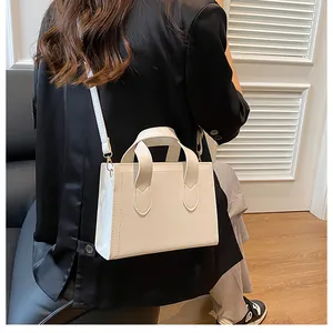 White minimalist rectangular crossbody bag styled with a professional black blazer