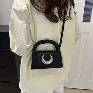 Minimalist black crescent buckle handbag shown on model for stylish commute look