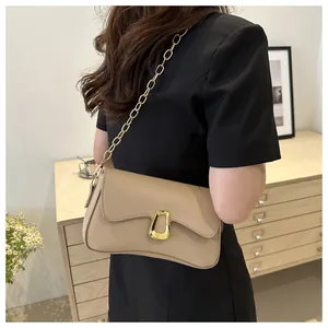 Detail of minimalist beige leather handbag with wavy flap and gold chain strap