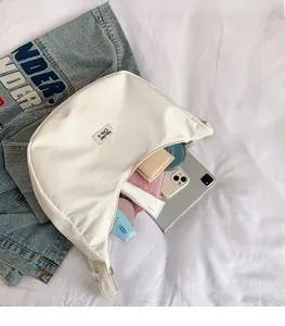 Interior view showing large storage capacity of white nylon crescent bag with items