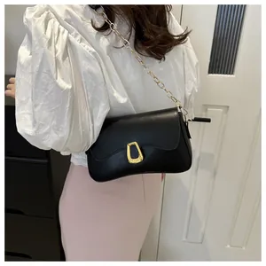 Detail of black PU leather shoulder bag featuring a gold chain strap and stylish matte buckle