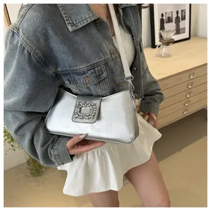 Detailed view of silver metallic shoulder bag featuring a sparkling crystal buckle detail
