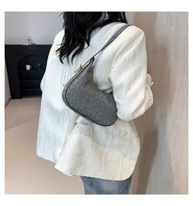 Detail of silver glitter crescent shoulder bag showing textured sequins and metallic shine