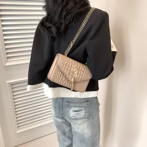 Sac bandoulière beige à texture crocodile avec chaîne dorée et détail de gland en métal