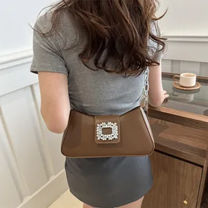 Chic dark brown leather underarm bag featuring a crystal-embellished buckle and silver chain