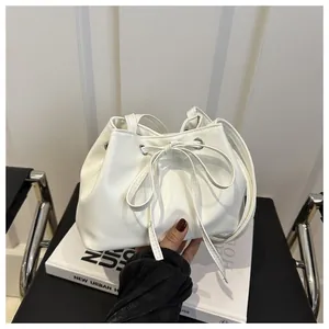 Close-up of white PU leather drawstring bucket bag with a delicate bow detail