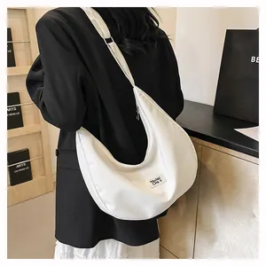Detailed view of the white waterproof nylon crescent bag with adjustable shoulder strap