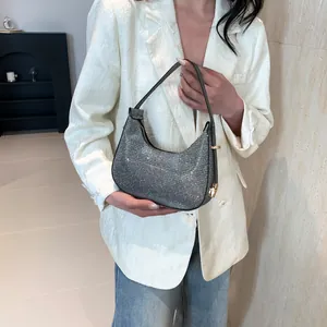 Sparkling silver rhinestone crescent handbag with gold hardware and top handle design