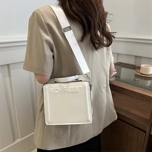 Chic white crossbody tote bag with Rich Rabbit embossed lettering and wide strap
