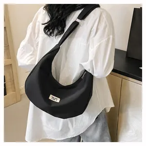 Detail of black waterproof nylon hobo bag with adjustable strap and brand label