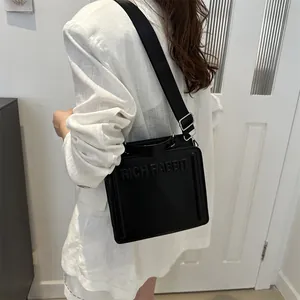 Black rectangular crossbody tote bag with embossed Rich Rabbit logo and wide strap