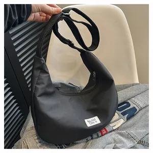 Macro detail of black nylon moon bag with adjustable strap and brand logo label