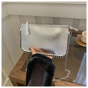 Nahaufnahme silberne Umhängetasche mit Metallkette und modischen Nietendetails