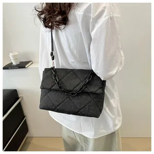 Detailed back view of a black quilted denim envelope bag with gold chain and strap