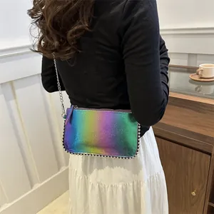 Irisierende Umhängetasche mit silberner Perlenverzierung und Kette am Modell gezeigt