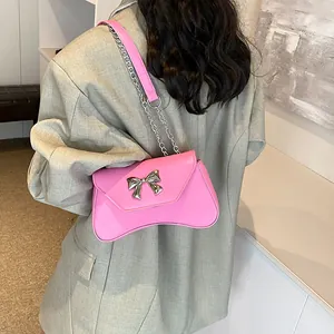 Pink patent leather shoulder bag with silver metal bow and chain strap for women
