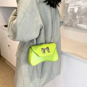 Neon green crossbody bag with silver bow buckle and metal chain strap for women